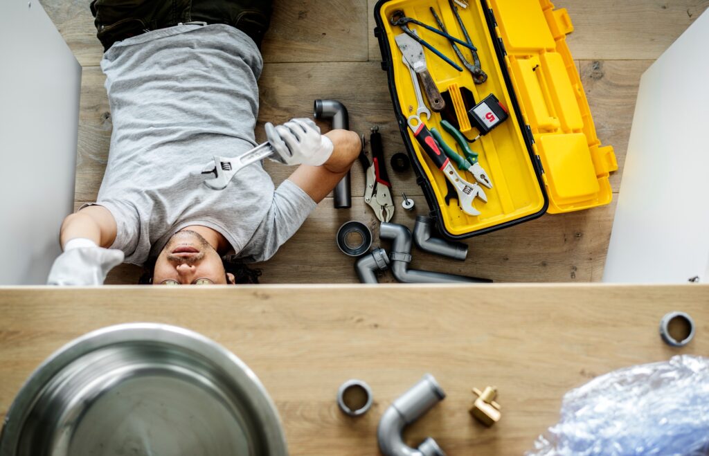 How Find Water Leak in House - Man fixing kitchen sink