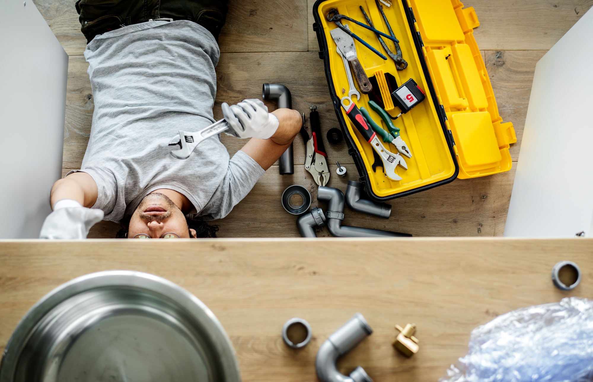 How Find Water Leak in House - Man fixing kitchen sink